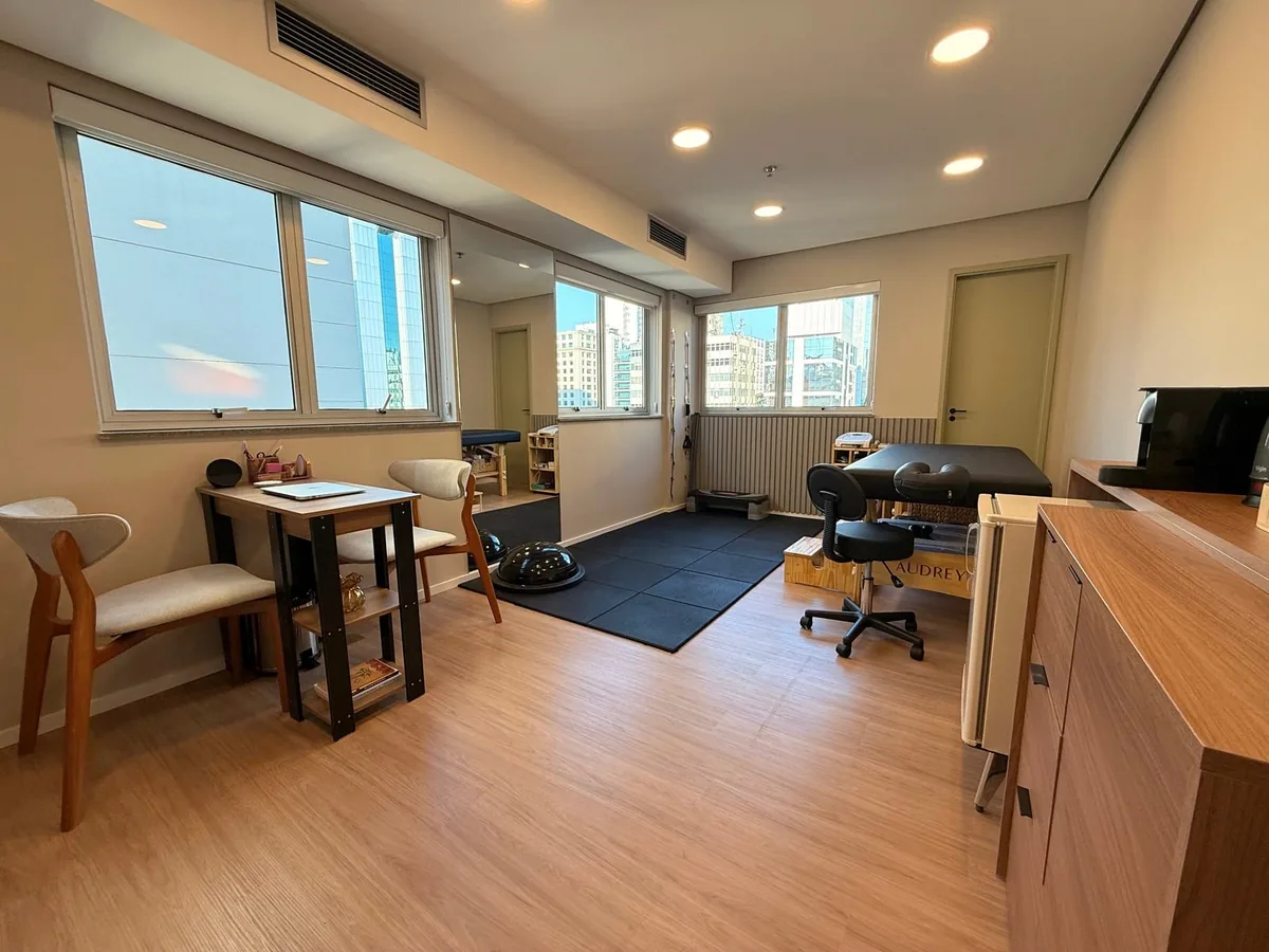 Sala de atendimento da clínica, com janelas amplas e piso de madeira